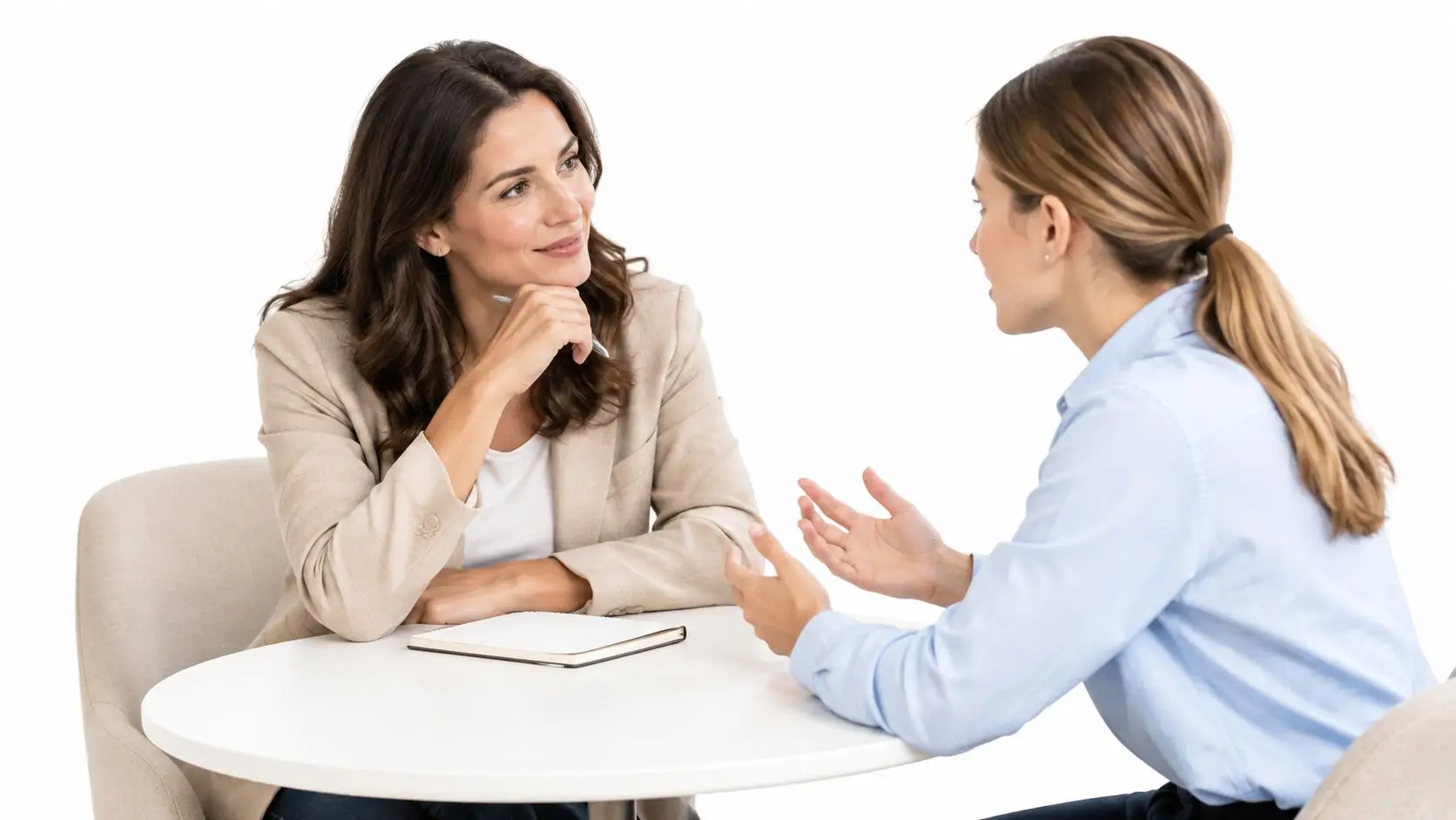 Una manager donna ascolta attentamente una candidata durante un colloquio di lavoro professionale in ufficio luminoso.